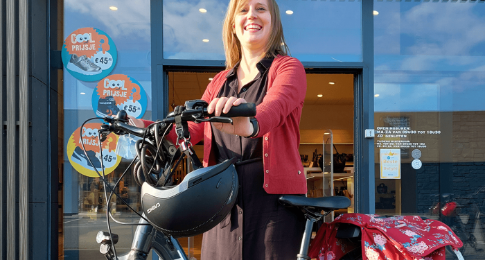 Winkelmanager Isabel Debecker poseert met fiets met batterij van Bosch eBike Systems voor haar winkel