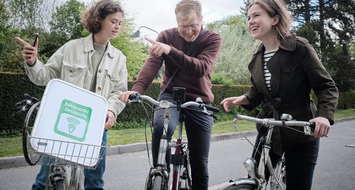 Groepje van drie fietsers gebruiken Bikenode, een app om een route door Brussel te plannen.