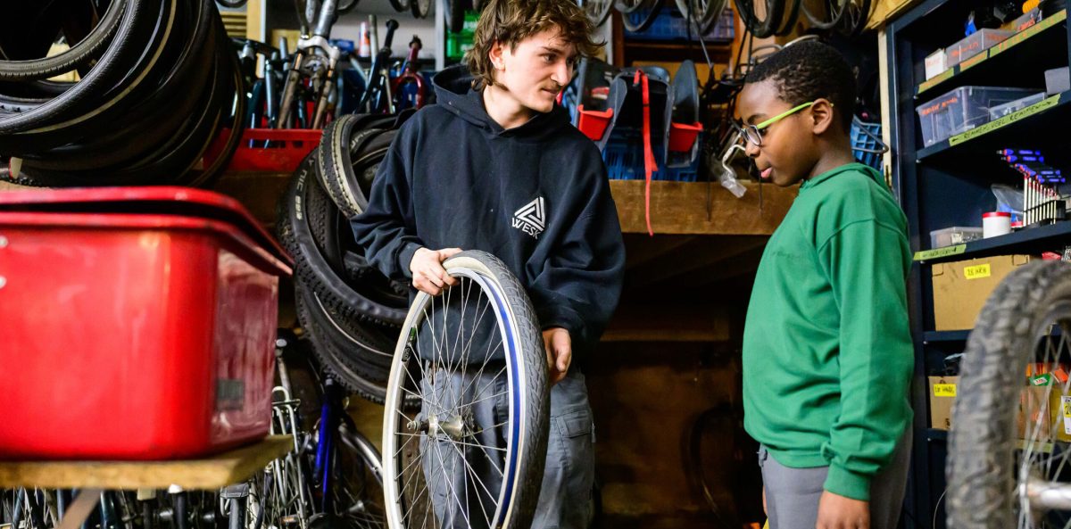 Instructeur geeft uitleg aan jongere in fietsatelier